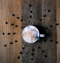 coffee cup with radiating coffee beans on wood 