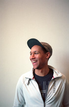 a man laughing in a ball cap
