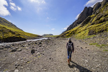 a woman walking beside of a river in Iceland 