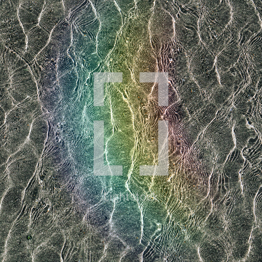 rainbow reflected on the water ripples, abstract background