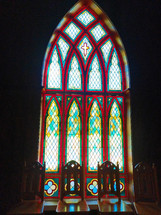 Arched stained glass window and chairs