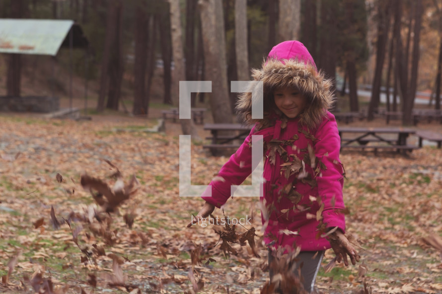 child playing in fall leaves 