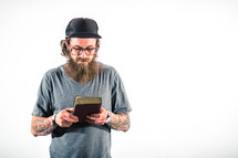 man with tattoos holding a Bible and praying 