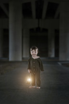 a toddler boy in pajamas holding a lantern 