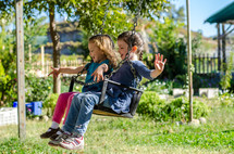 children swinging on a swing on a playground 
