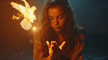 A young girl praying with a fiery dove next to her