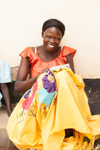 Smiling woman in a colorful dress.