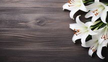 White lily flowers on wooden background. Top view with copy space