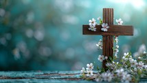 Wooden cross with white flowers on an old wooden background. Easter background
