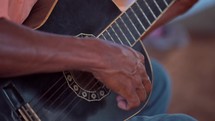 Close up of man's hand playing guitar in small church service