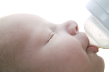 Two week old caucasian baby nursing bottle of milk