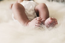 newborn feet on a fuzzy rug 