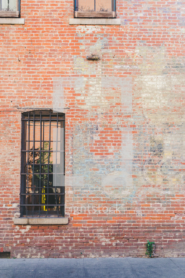 barred windows on a brick wall 