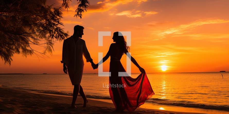 Silhouette of romantic couple on the beach at beautiful sunset.