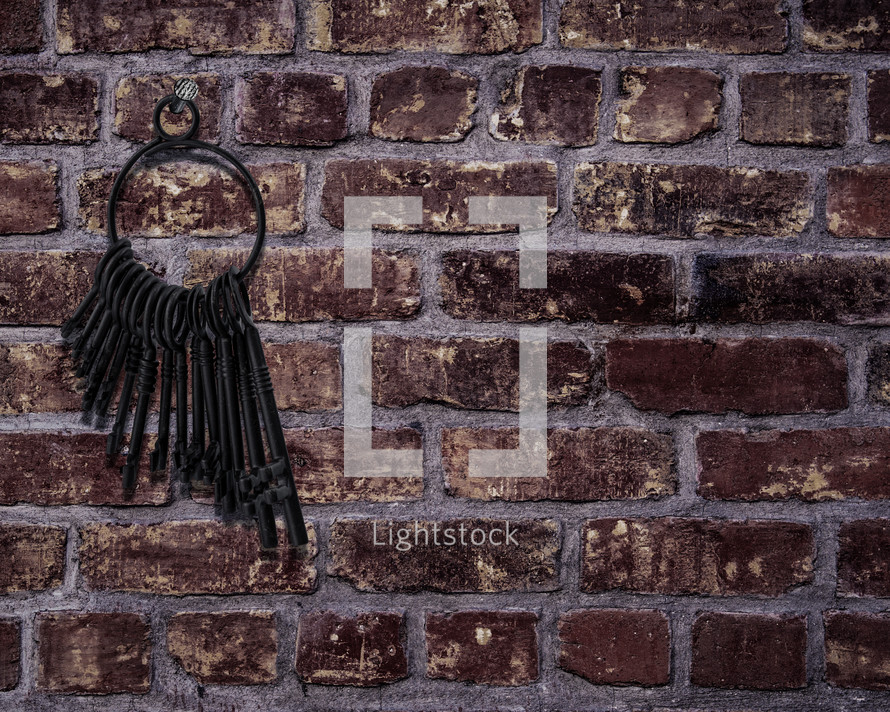 skeleton keys on a ring against a brick wall 