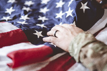 military man with hand on American flag 