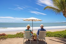 Senior couple sittingchairs on the beach looking at the sea