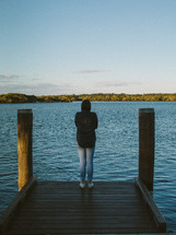 woman standing at the end of a dock