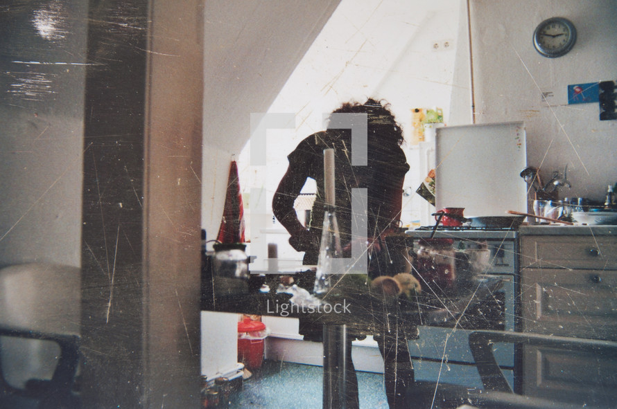 Scratched up photograph of person in a kitchen - vintage looking