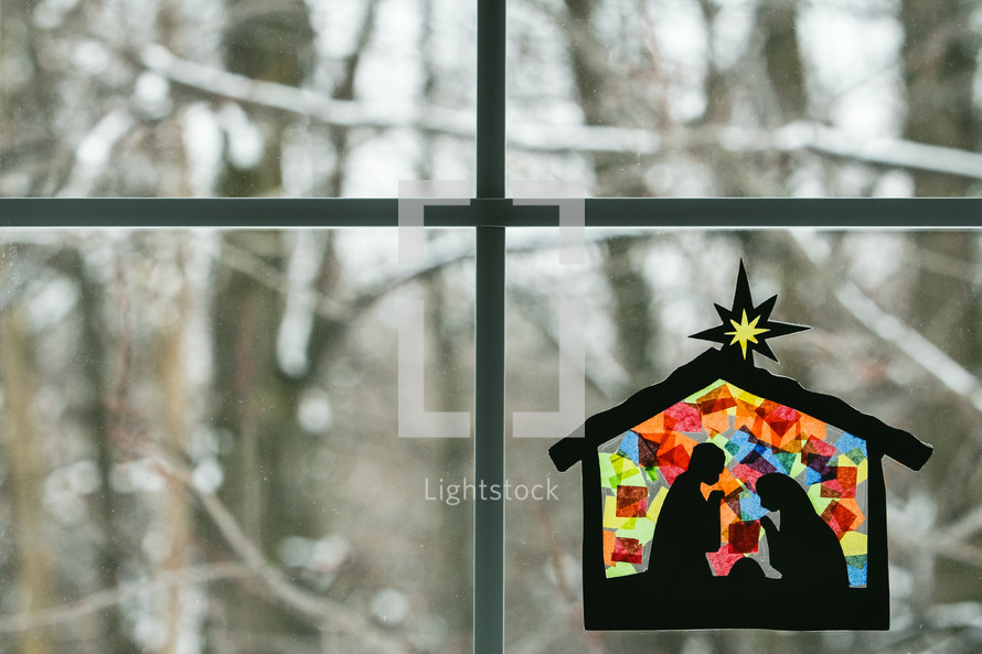 stained glass sun catcher children's craft hanging in a window 