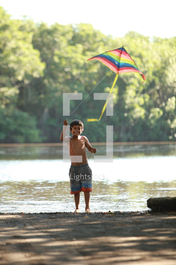 Boy flying kite by the river