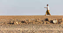 man walking across a desert in Ethiopia 