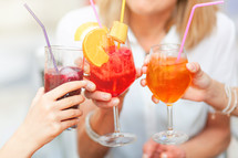 Cheers with different colored cocktails, red spritz, blueberry and orange spritz.