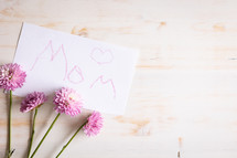 Word mom written on a paper with purple flowers