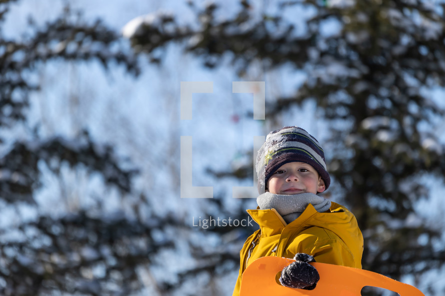 child with a sled in the snow 