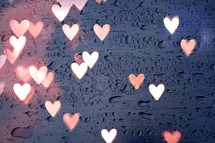 lights of heart shape on the window with drops