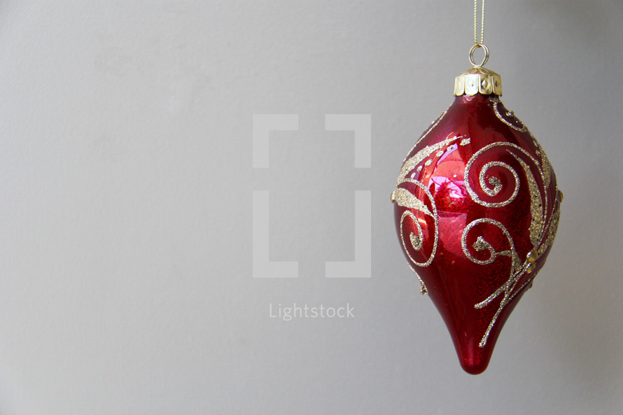 red and gold hanging Christmas ornament  agains white background