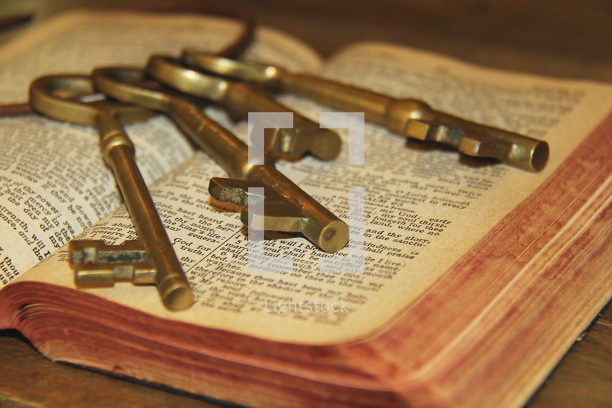 Large bunch of keys on the pages of an old Bible 
