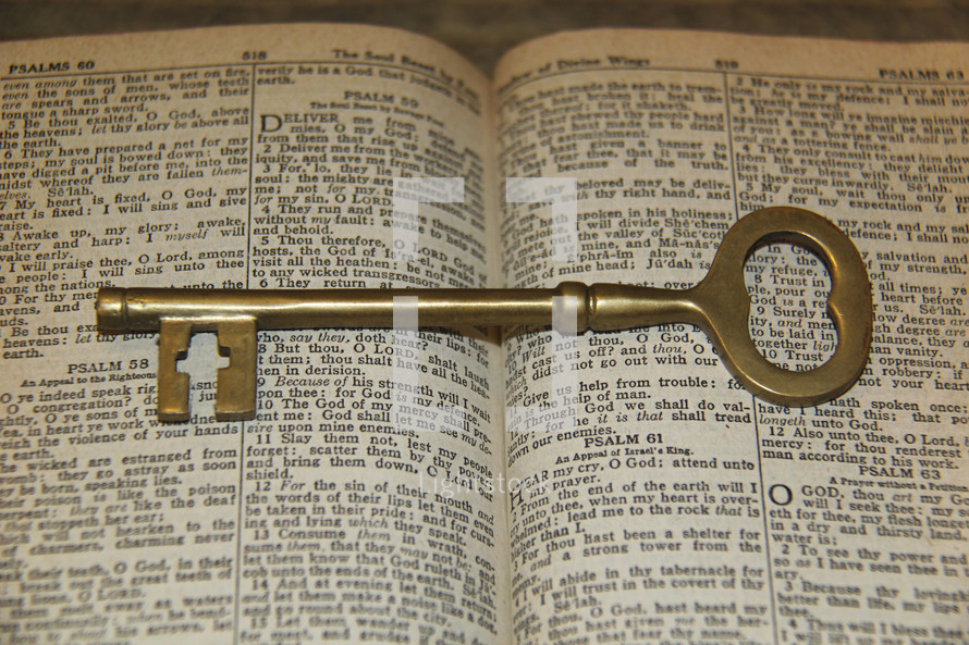 Brass skeleton key on the open pages of a Bible