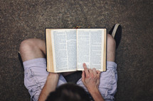 young man reading a Bible in his lap 
