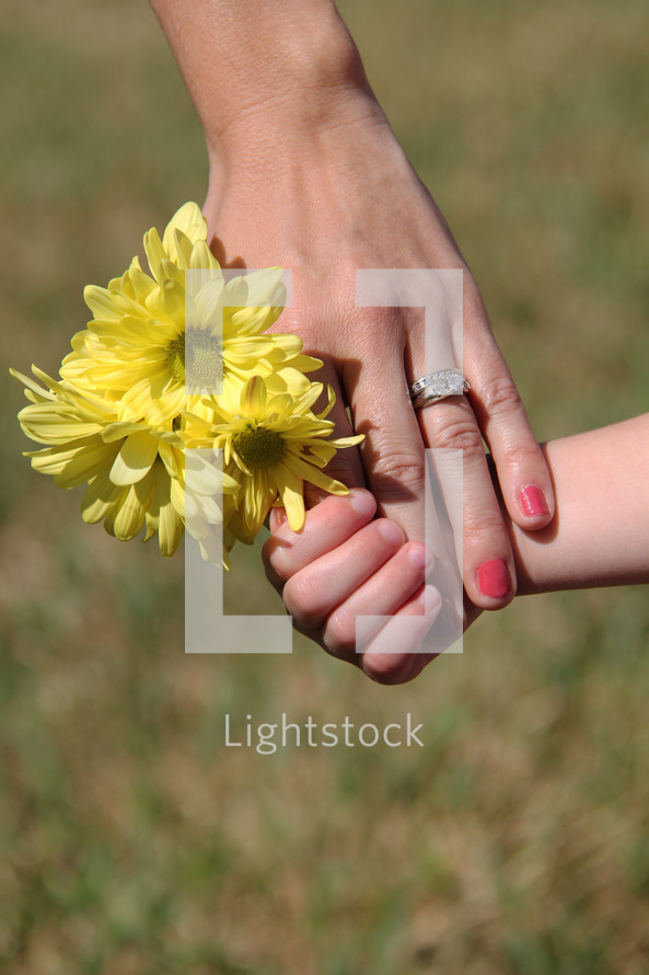 Mother and child's hands with flowers