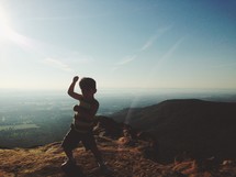 little boy at the top of a mountain - karate pose 