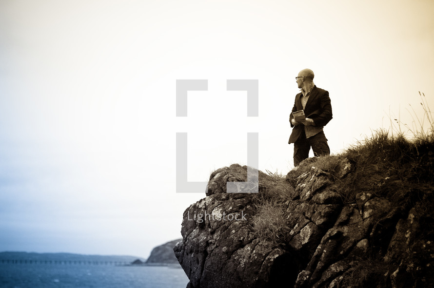 a man standing near the edge of a sea cliff 