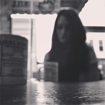 blurry image of a woman sitting in a coffee shop