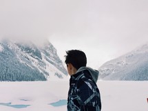 Man looking at the snow-covered mountains.