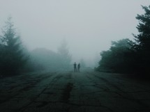 men standing in fog on a mountain top 