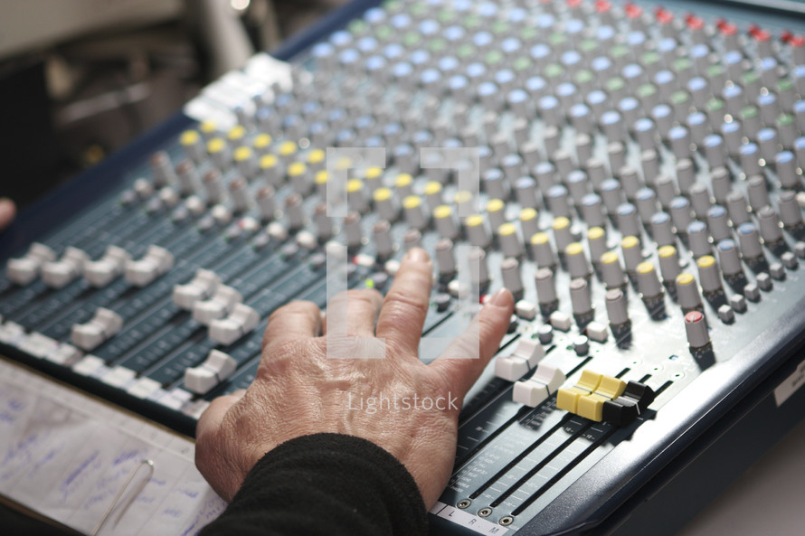 man's hand on a soundboard