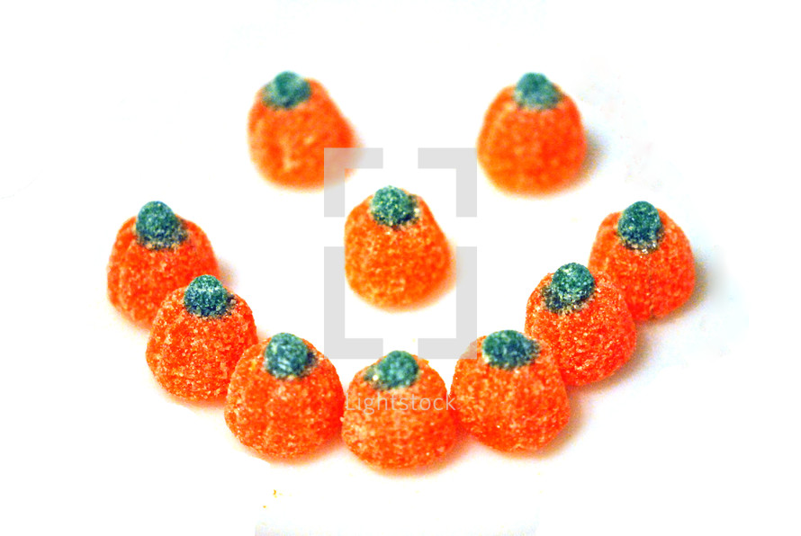 Orange gumdrop candy pumpkins arranged to form a smiley face.