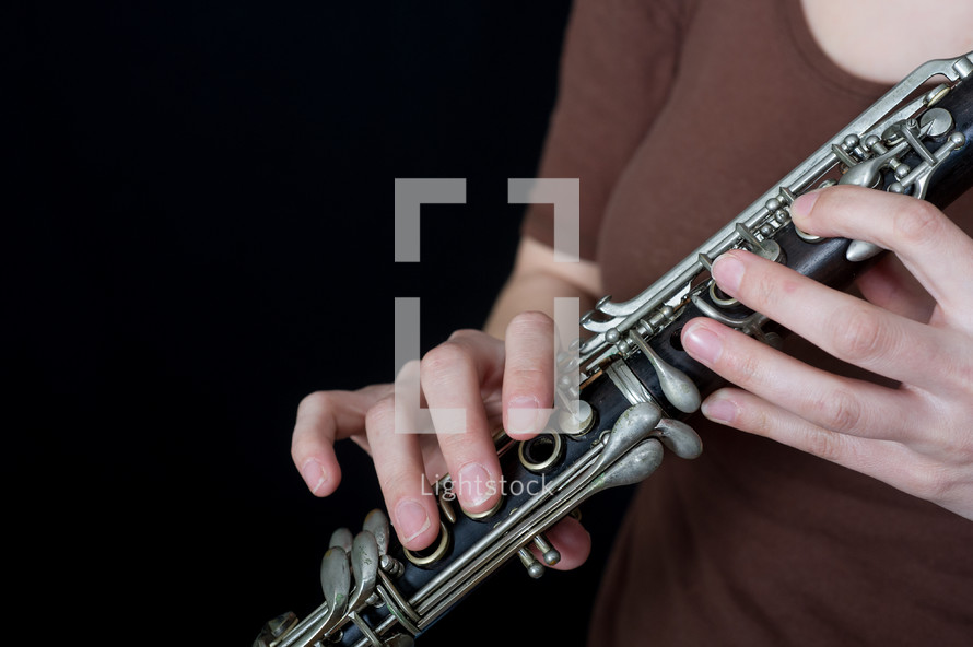Hands holding an oboe.