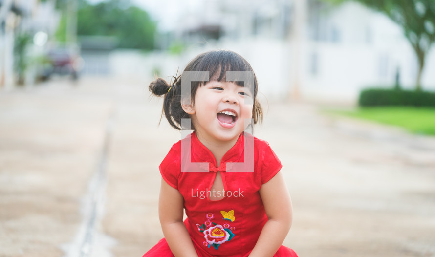 Happy Little asian girl in chinese traditional dress laughing and smiling