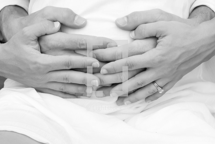 hands of a couple on a pregnant belly 