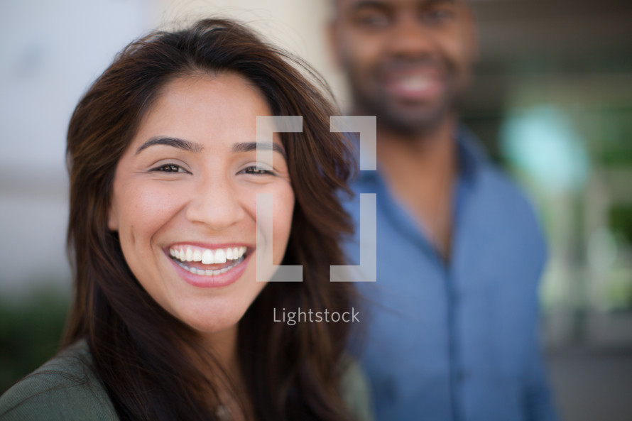 smiling man and woman standing outdoors 
