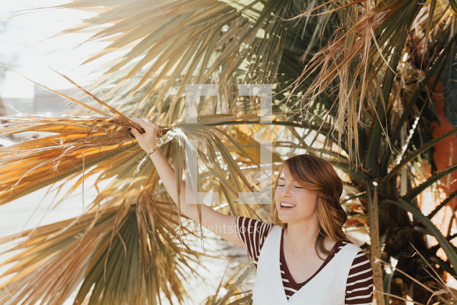 a woman holding onto a palm tree 