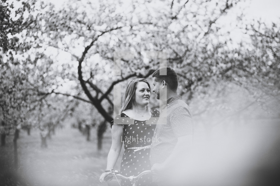 happy couple standing in an orchard 