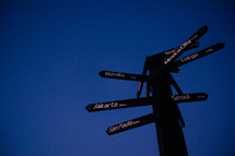 sign pointing directions against a blue sky 