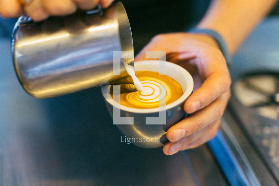 man pouring cream in coffee 